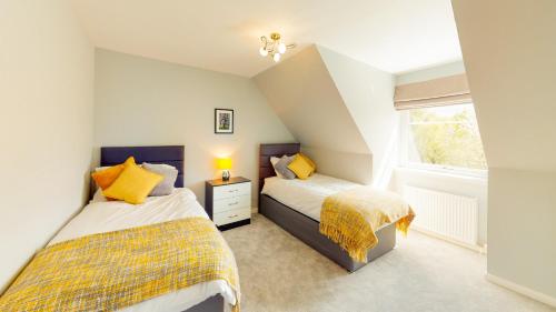 two beds in a small room with a window at Braeside - Family home in Nethy Bridge in Nethy Bridge