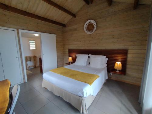 a bedroom with a bed with a wooden wall at Les Coeurs d'Amants in Saint-Joseph