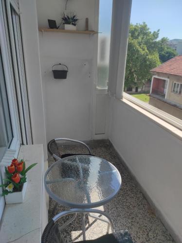a table and two chairs on a balcony with a window at Apartman Ana in Čapljina