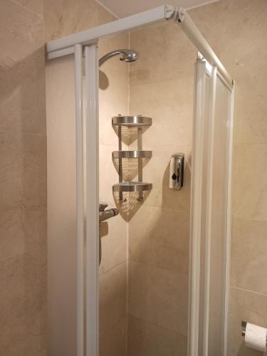 a shower with a glass door with a chandelier at Beach Apartment Puerto Banus Marbella in Estepona