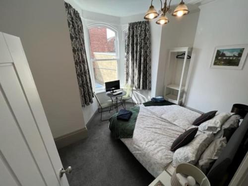 a bedroom with a bed and a desk and a window at 2 Bed ground floor apartment, sleeps 4 with free parking in Harrogate