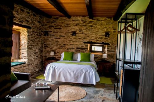 een slaapkamer met een bed met groene kussens bij Casa Rural Dana 