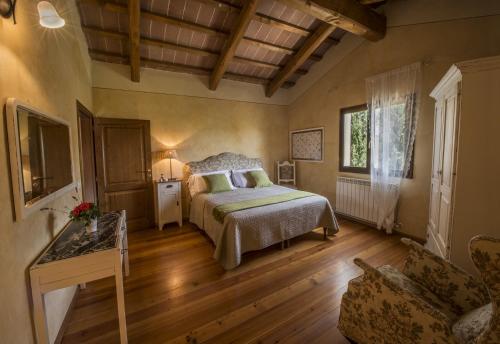 Un dormitorio con una cama y un sofá en una habitación. en Villa degli Amanti - Homelike Villas, en Terranuova Bracciolini