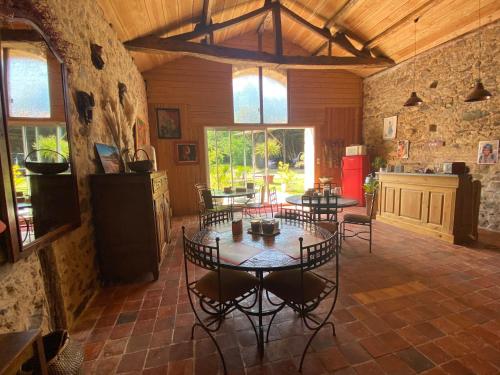 een eetkamer met tafels en stoelen in een gebouw bij La Frapperie in La Pommeraie-sur-Sèvre