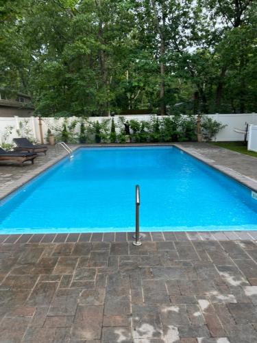 East QuogueにあるHamptons Getawayの庭の青い水のスイミングプール