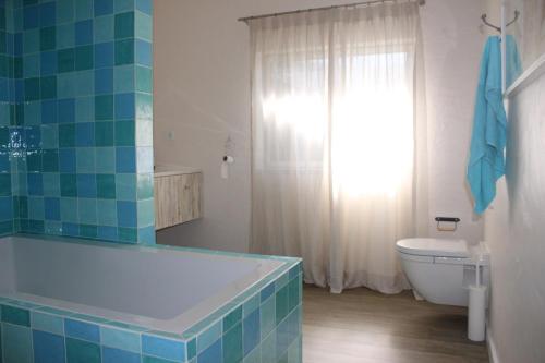 a bathroom with a tub and a toilet at Quintinha do Poceirão in Águas de Moura