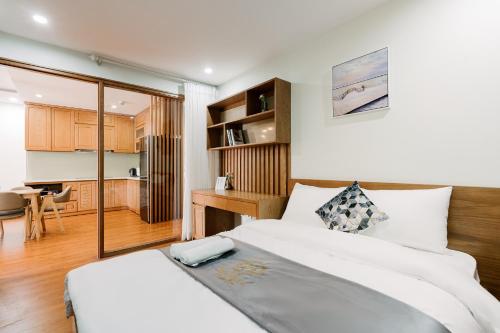 ハノイにあるHi-Home Suites - the West Lake Xuan Dieuのベッドルーム1室(ベッド2台付)、キッチンが備わります。