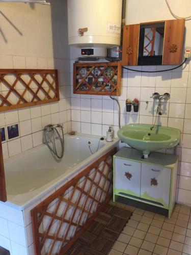 a bathroom with a green sink and a tub at Romantická drevenica in Liptovská Osada
