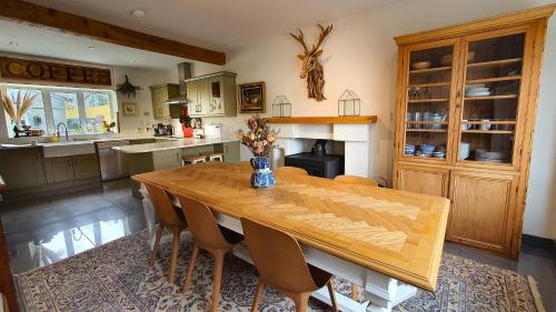 eine Küche mit einem Holztisch und einigen Stühlen in der Unterkunft Rose House in Glenarm