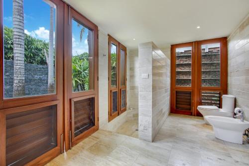 a bathroom with two sinks and a toilet and a window at Luxurious 8-BR Villa with Ocean View, Jacuzzi, Home Cinema and Resort Access in Casa de Campo in La Romana