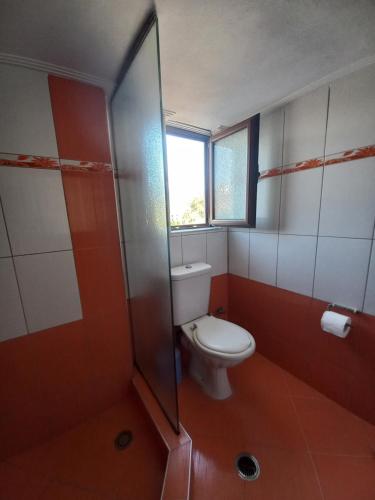 a bathroom with a toilet and a window at Arjana & Nelaj Apartments in Ksamil