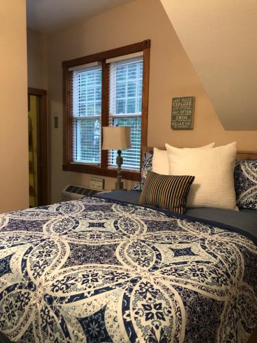 a bedroom with a bed with a blue and white blanket at Lakeside Suites in Elkhart Lake
