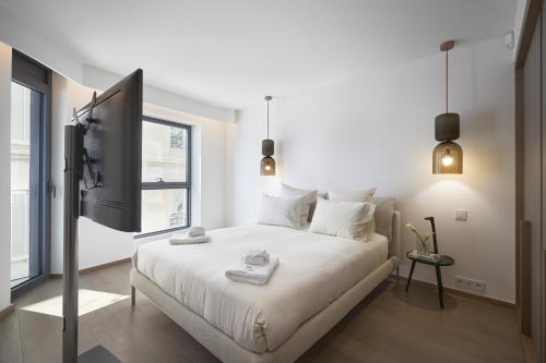 - une chambre blanche avec un lit et une télévision dans l'établissement Ref F501 - Palmes d'Or Properties, à Cannes