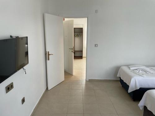 a room with two beds and a flat screen tv at Parli Hotel in Gokceada Town