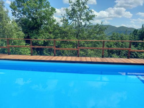 a swimming pool with a wooden fence and trees at Valle Dame in Cortona