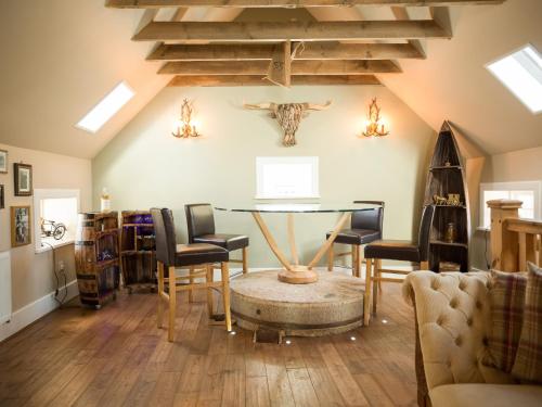 a living room with a table and chairs at The Maltings - lodge with hot tub in Nethy Bridge