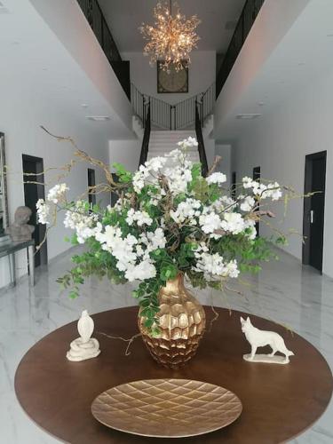 Un jarrón lleno de flores blancas sobre una mesa. en MAXOR PALACE, en Protaras