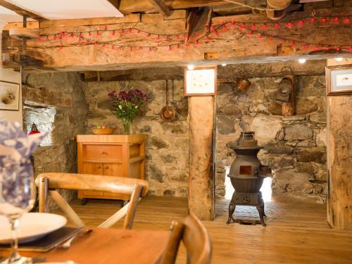 a room with a table and a wood stove at The Maltings - lodge with hot tub in Nethy Bridge
