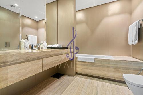 La salle de bains est pourvue d'un lavabo, d'une baignoire et d'un miroir. dans l'établissement Walaa Homes Luxury 2Bedroom at DAMAC Exclusiva Tower Riyadh Saudia-1904, à Riyad