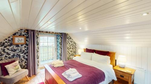 a bedroom with a large bed and a window at The Maltings - lodge with hot tub in Nethy Bridge