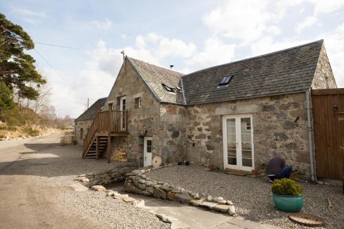 an old stone house with a gravel driveway at The Maltings - lodge with hot tub in Nethy Bridge