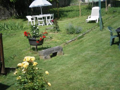 a garden with a table and chairs and flowers at le Marboré in Esquièze - Sère