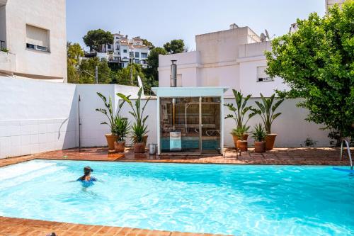 a woman swimming in a swimming pool on top of a building at Villa Fresa in Fuengirola