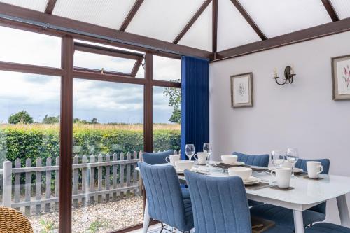 een eetkamer met een tafel en stoelen en een raam bij 2 Bedroom Rural Escape In Peaceful Elmswell in Woolpit