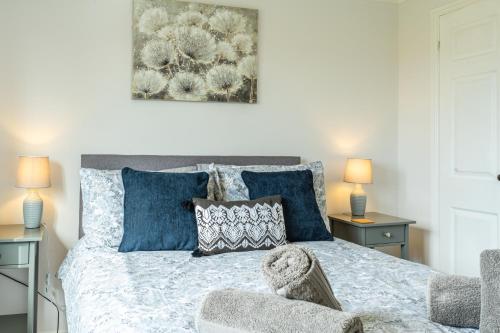 a bedroom with a bed with blue pillows at 2 Bedroom Rural Escape In Peaceful Elmswell in Woolpit