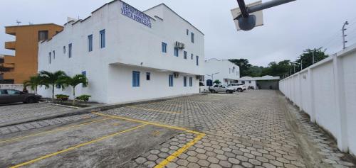 un edificio blanco en una calle al lado de un aparcamiento en Departamento en Tonsupa en Tonsupa