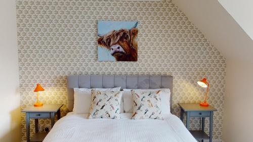 a bedroom with a bed with a cow on the wall at Eagle Lodge - Aviemore Lodges in Aviemore