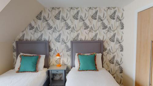 two beds sitting next to each other in a bedroom at Eagle Lodge - Aviemore Lodges in Aviemore