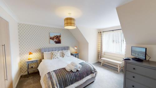 a bedroom with a bed with a teddy bear on it at Eagle Lodge - Aviemore Lodges in Aviemore