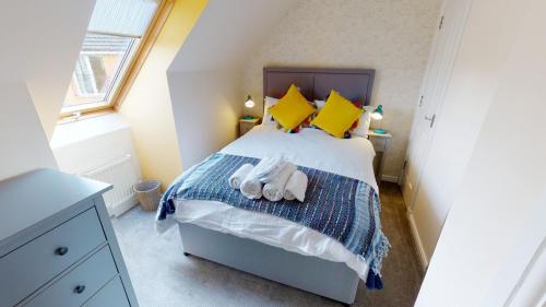 a bedroom with a large bed with yellow pillows at Eagle Lodge - Aviemore Lodges in Aviemore