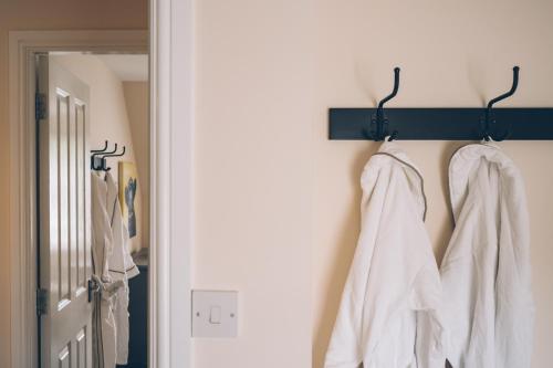 a hallway with white shirts hanging on a wall at Eagle Lodge - Aviemore Lodges in Aviemore