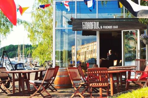a group of chairs and tables outside of a restaurant at Beautiful apartment near forest, sea and city in Sandefjord