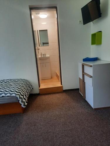 a room with a bed and a bathroom with a mirror at Penzion a restaurace Windows in Mařenice
