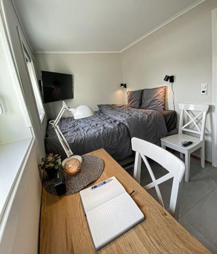a small room with a bed and a table with a desk sidx sidx sidx at Beautiful apartment near forest, sea and city in Sandefjord
