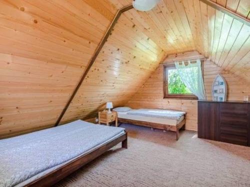 米科瓦伊基的住宿－Idea Domki，小木屋内设有一间带两张床和窗户的卧室