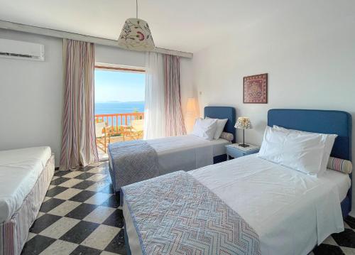 a hotel room with two beds and a balcony at Casa Bianca Elegant House Near Beach in Spetses