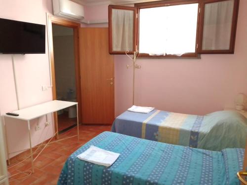 a small room with two beds and a television at Affitta camere San Miniato in San Miniato