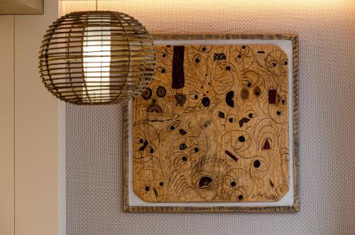 a painting of eyes on a wall with a lamp at OMID Saldanha Hotel in Lisbon
