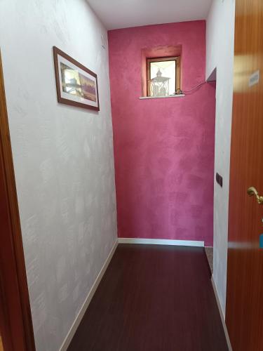 a hallway with a purple wall and a window at B&b Panoramic in Troina
