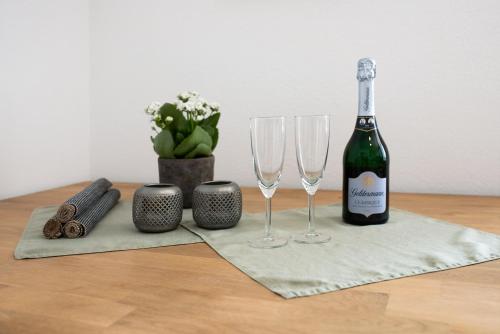 a bottle of wine and two wine glasses on a table at Haus Bergruh Fuchsbau in Todtnauberg