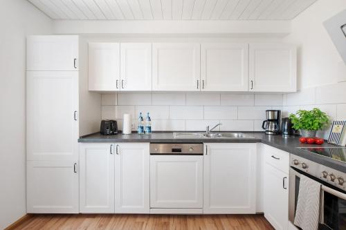 a white kitchen with white cabinets and a sink at Haus Bergruh Fuchsbau in Todtnauberg