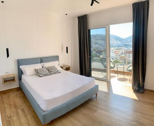 a bedroom with a bed and a large window at Villa Saral Mar in Sarandë