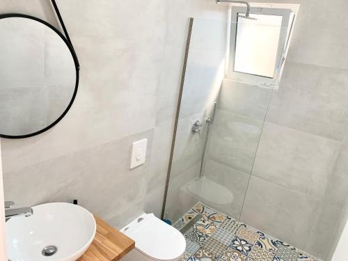 a bathroom with a shower and a sink and a mirror at Villa Saral Mar in Sarandë