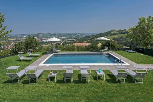 a swimming pool with chairs and a table at Villa Zeta / Design Villa with Private Pool in Canelli