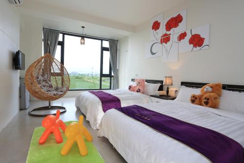 a bedroom with two beds with stuffed animals on the floor at Flower B & B in Dongshan