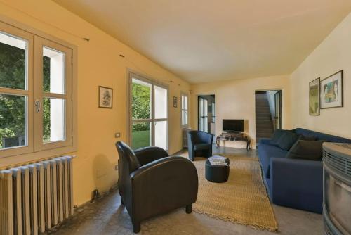 a living room with a blue couch and chairs at Villa Zeta / Design Villa with Private Pool in Canelli